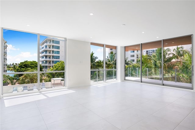 tiled empty room featuring expansive windows