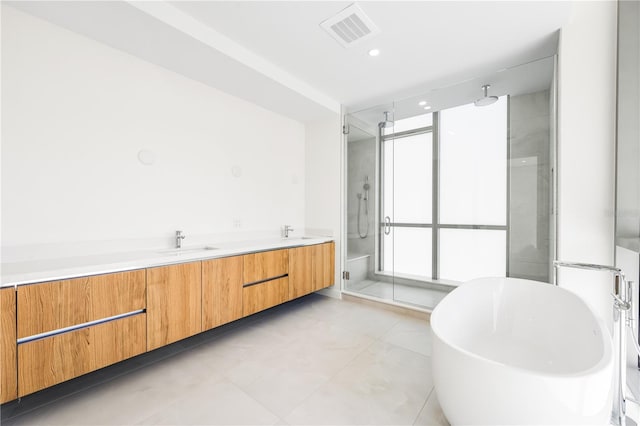 bathroom with vanity and shower with separate bathtub