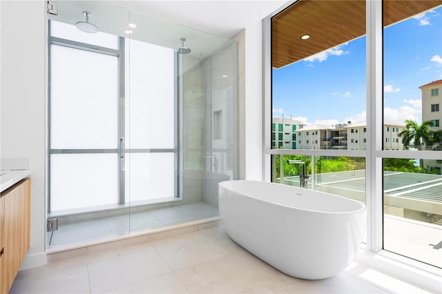 bathroom featuring tile patterned flooring, plus walk in shower, and vanity