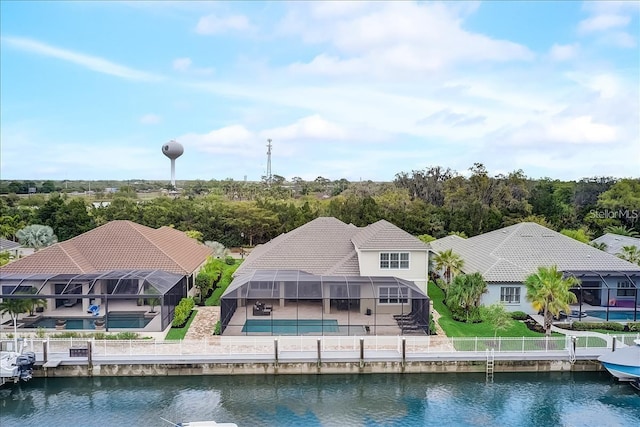 back of property featuring glass enclosure, a water view, a swimming pool, and a patio