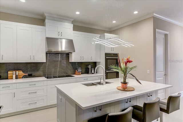 kitchen with light tile patterned floors, white cabinetry, sink, black appliances, and a kitchen island with sink