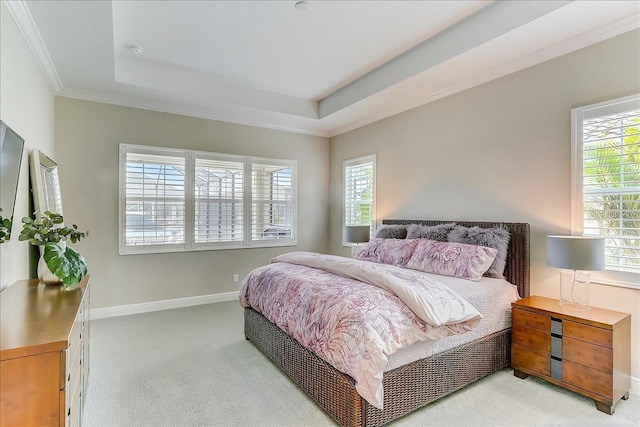 carpeted bedroom featuring multiple windows, a raised ceiling, and crown molding