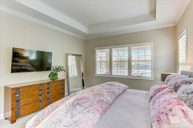 bedroom with a tray ceiling, crown molding, and light colored carpet