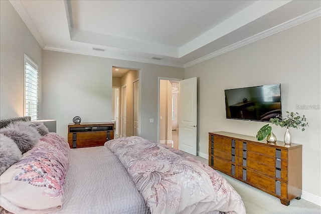 bedroom with a tray ceiling, crown molding, and light colored carpet