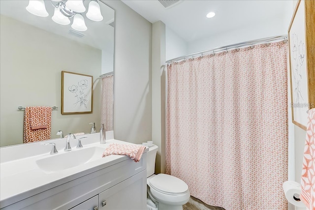 bathroom featuring curtained shower, toilet, a notable chandelier, and vanity