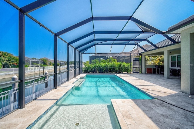 view of pool with glass enclosure and a patio