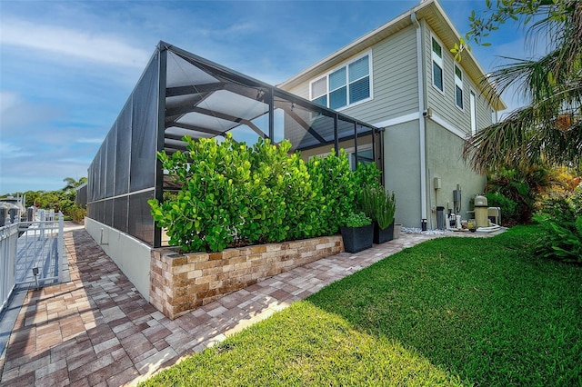 exterior space with glass enclosure and a yard