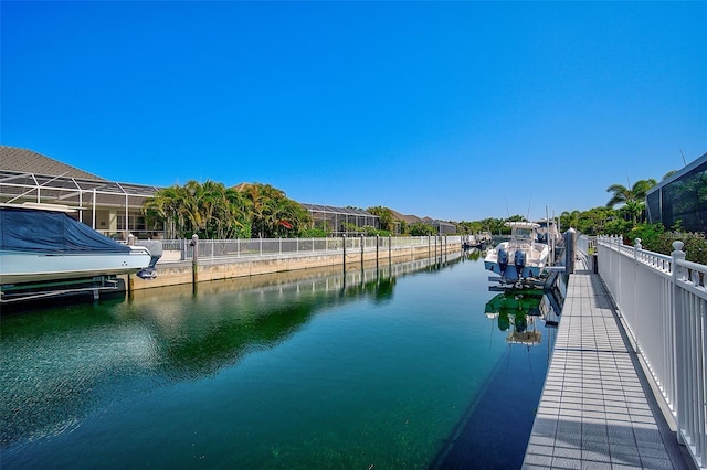 view of dock with a lanai and a water view