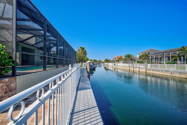 dock area featuring a water view and glass enclosure