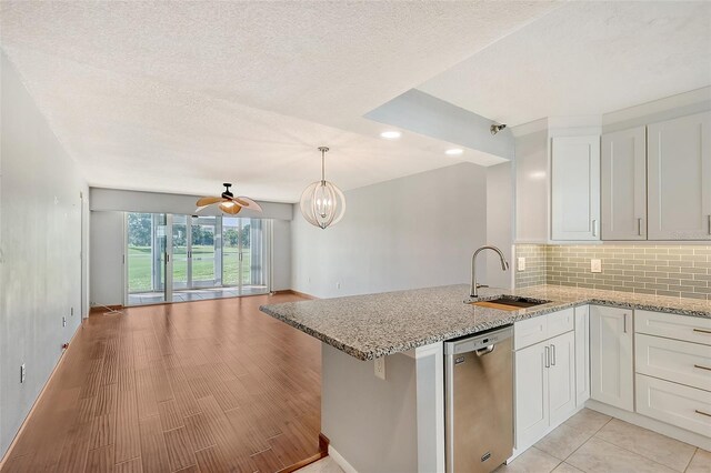 kitchen with dishwasher, white cabinets, kitchen peninsula, and sink