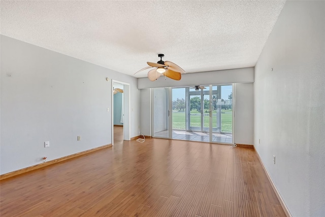 empty room with ceiling fan, light hardwood / wood-style floors, and a textured ceiling