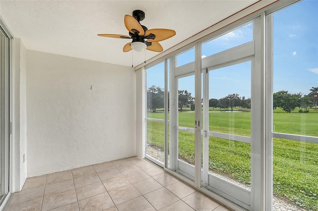 unfurnished sunroom with ceiling fan