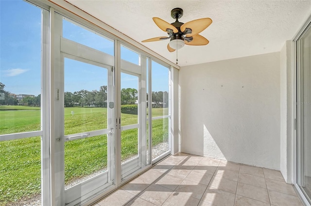 unfurnished sunroom with a wealth of natural light and ceiling fan