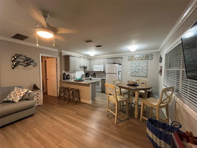 dining area featuring crown molding, ceiling fan, and light wood-type flooring