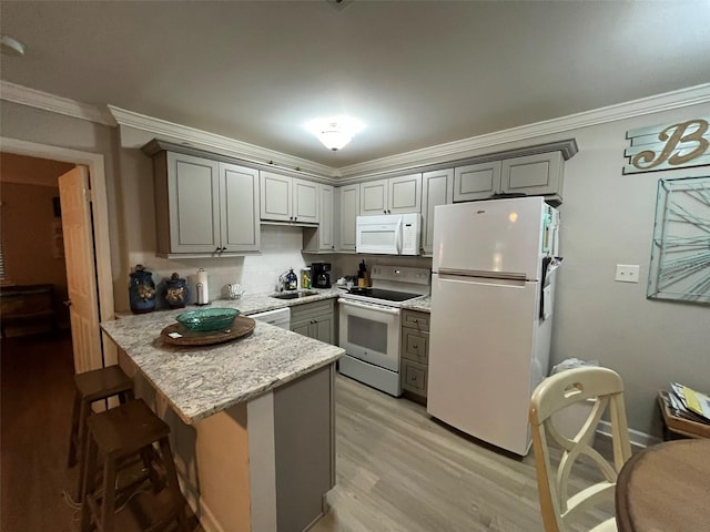 kitchen featuring kitchen peninsula, ornamental molding, gray cabinets, and white appliances