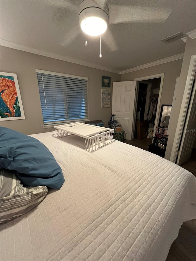 bedroom featuring ornamental molding, a textured ceiling, ceiling fan, and a closet