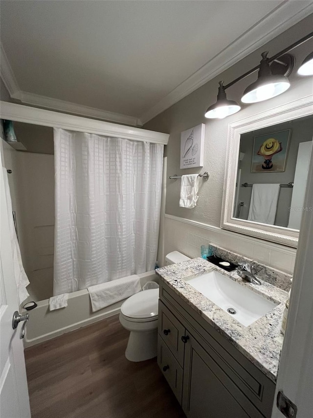 full bathroom featuring toilet, hardwood / wood-style floors, ornamental molding, vanity, and shower / tub combo with curtain