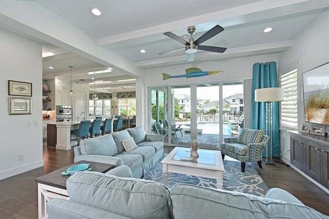 living room featuring beamed ceiling, dark hardwood / wood-style floors, sink, and ceiling fan