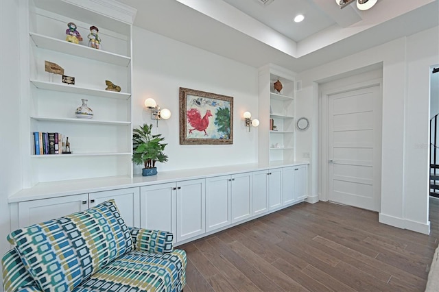 living area featuring built in features and dark hardwood / wood-style flooring