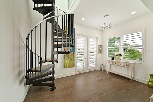 foyer with dark hardwood / wood-style floors and a chandelier