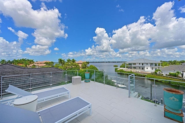 view of patio / terrace with a water view and a balcony