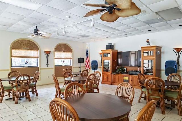 dining area featuring light tile patterned flooring, a paneled ceiling, and ceiling fan