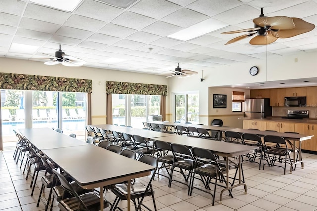 tiled dining area with a paneled ceiling and ceiling fan