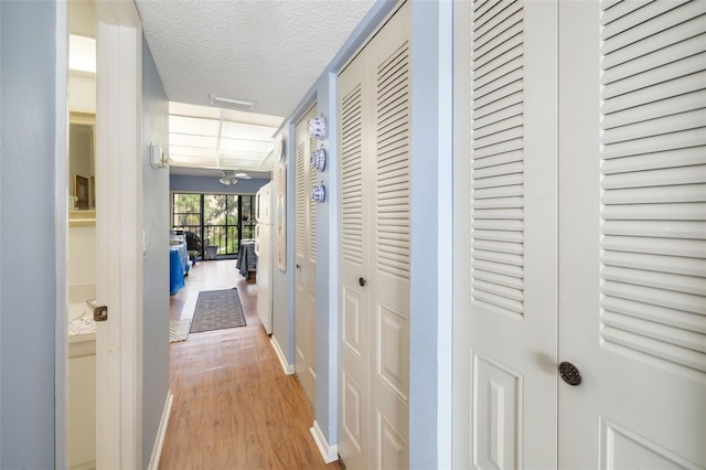 hall featuring a textured ceiling and wood-type flooring