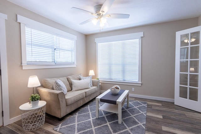 living room with dark wood-type flooring and ceiling fan