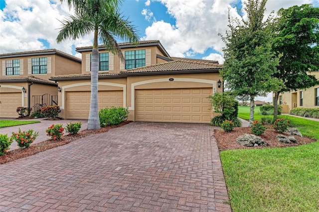 mediterranean / spanish home with a garage and a front lawn