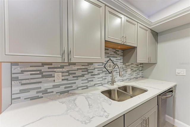 kitchen with gray cabinetry, light stone countertops, dishwasher, backsplash, and sink