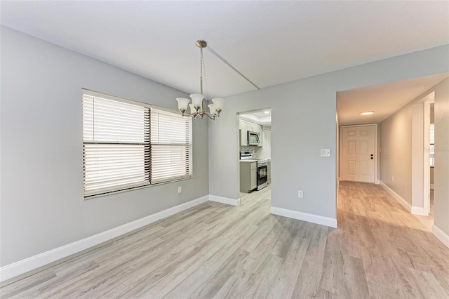 unfurnished dining area with an inviting chandelier and light hardwood / wood-style floors