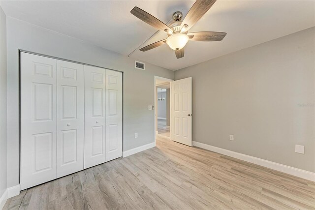 unfurnished bedroom with light hardwood / wood-style flooring, ceiling fan, and a closet