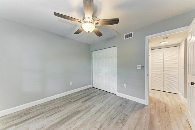 unfurnished bedroom featuring ceiling fan, a closet, and light wood-type flooring