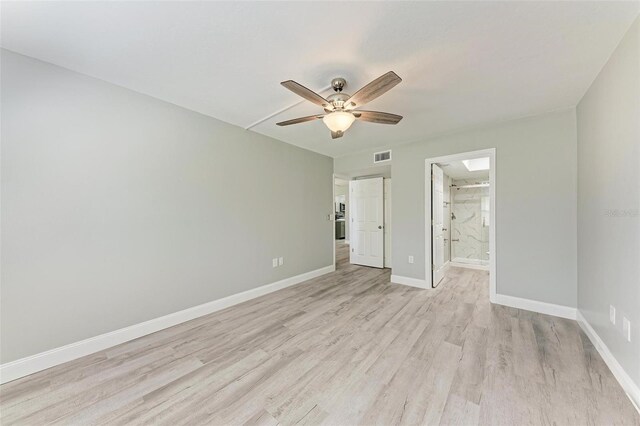 unfurnished bedroom with light hardwood / wood-style flooring, ceiling fan, and connected bathroom