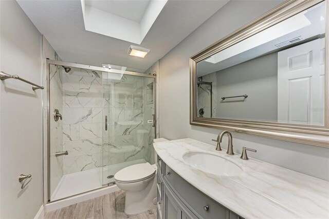 bathroom with vanity, toilet, hardwood / wood-style floors, and a shower with shower door