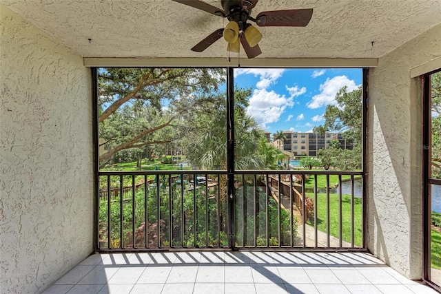 unfurnished sunroom featuring ceiling fan