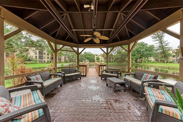 view of patio featuring a water view, a gazebo, ceiling fan, and an outdoor hangout area