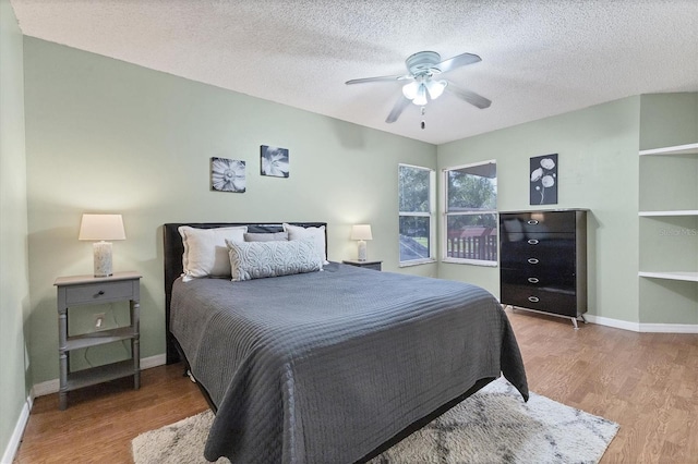 bedroom featuring a textured ceiling, wood finished floors, and baseboards