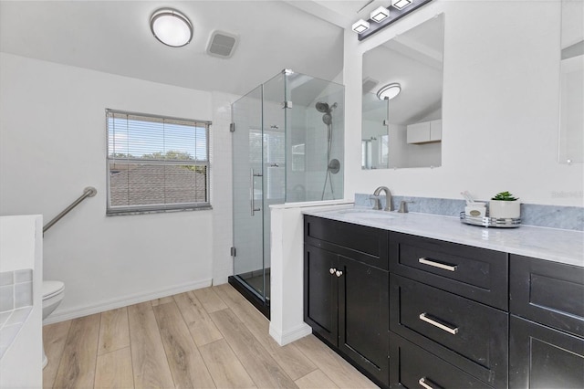 full bathroom with toilet, a stall shower, wood finished floors, and visible vents