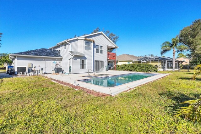 rear view of house with a fenced in pool, a yard, a jacuzzi, and a patio