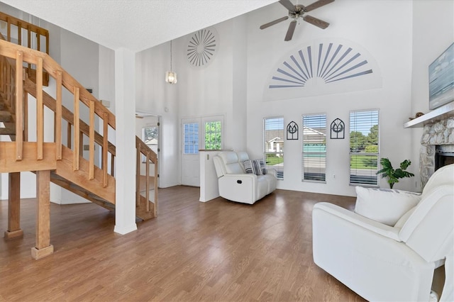 entryway with a wealth of natural light, stairs, a fireplace, and wood finished floors