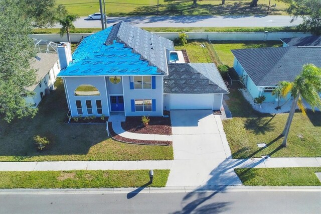 view of front facade featuring a garage, driveway, a chimney, and a front lawn