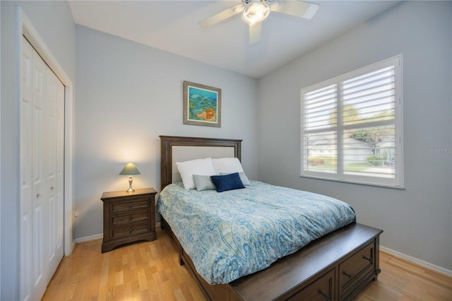 bedroom featuring ceiling fan, baseboards, a closet, and light wood-type flooring