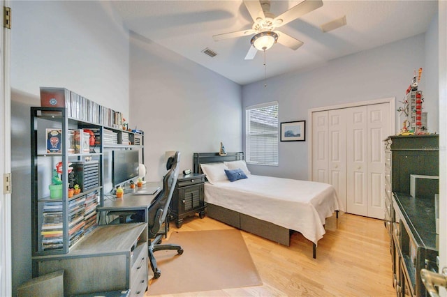 bedroom with light wood finished floors, visible vents, ceiling fan, and a closet