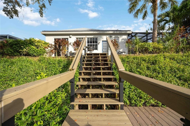 exterior space with stairway, stucco siding, and a wooden deck