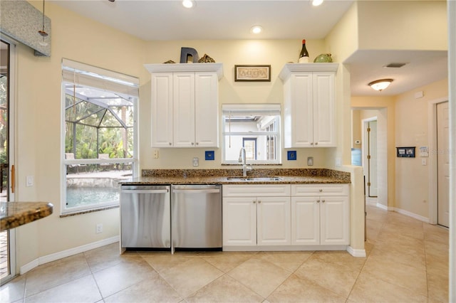 kitchen with plenty of natural light, dishwasher, dark stone counters, and a sink