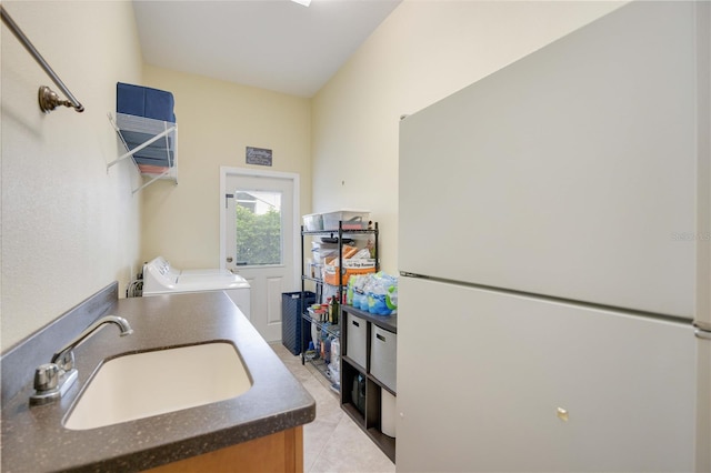 washroom featuring washer and clothes dryer, laundry area, and a sink