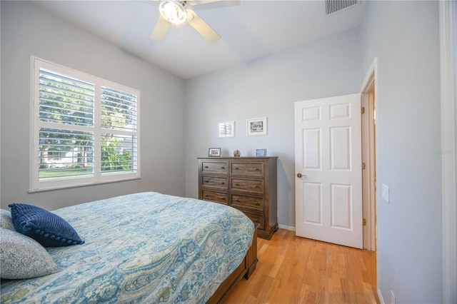 bedroom featuring visible vents, baseboards, light wood-style floors, and a ceiling fan