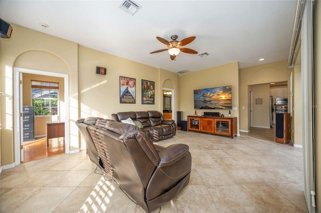 living area with visible vents, baseboards, and ceiling fan